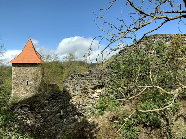 Turm mit rotem Dach und Steinmauer einer alten Burganlage