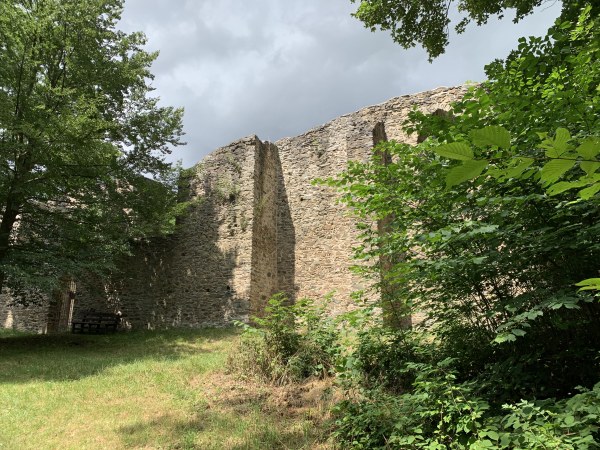 Auf Wiese unter blauem Himmel Ruinenmauer