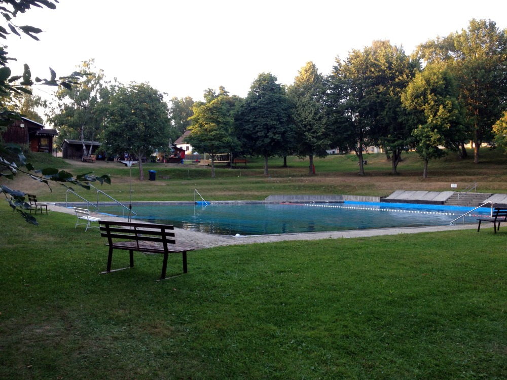 Schwimmbad im Freien mit Bank mit viel Platz zum Liegen auf Wiese