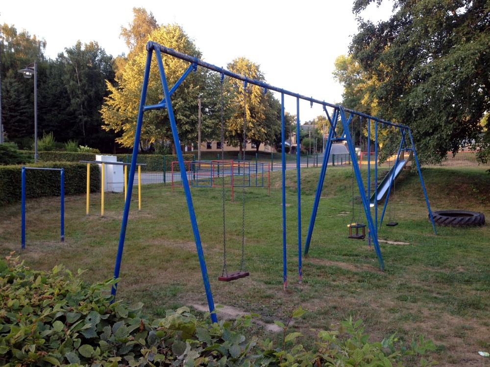 Schaukel mit blauem Gestell am Abend