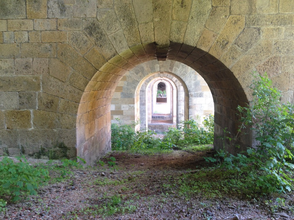 Blick ziemlich weit unten weit von der Seite lngs durch die Gltzschtalbrcke durch zahlreiche Rundbgen auf eine Touristengruppe