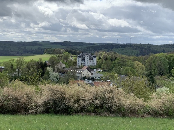 Huser inmitten Wald- und Wiesenlandschaft