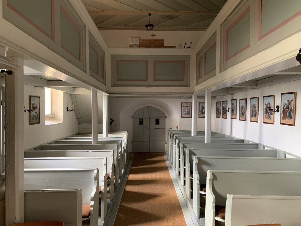 In der Kirche: Blick von der Kanzel auf den Ausgang. Rechts und links Sitzbnke.