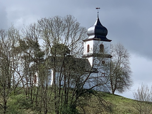 Kirche auf Hgel hinter Bumen