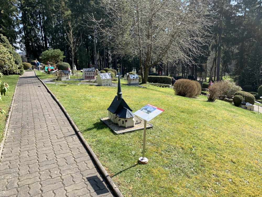 Park auf Wiese mit Miniatur-Modellen von beudeutsamen Gebuden des Vogtlandes im Wald