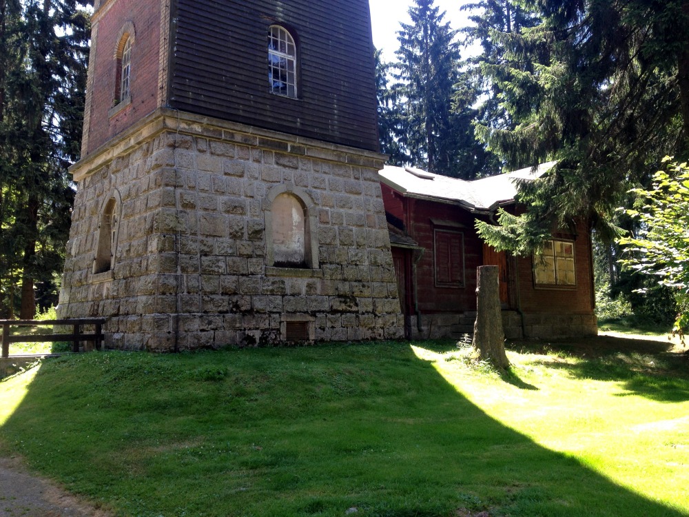 Fu des Turmes aus Stein auf Wiese in Schatten mit Htte