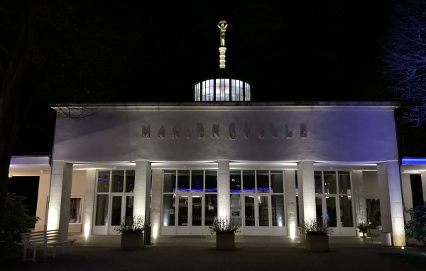 Weißes Gebäude in der Nacht mit der Aufschrift: Marienquelle