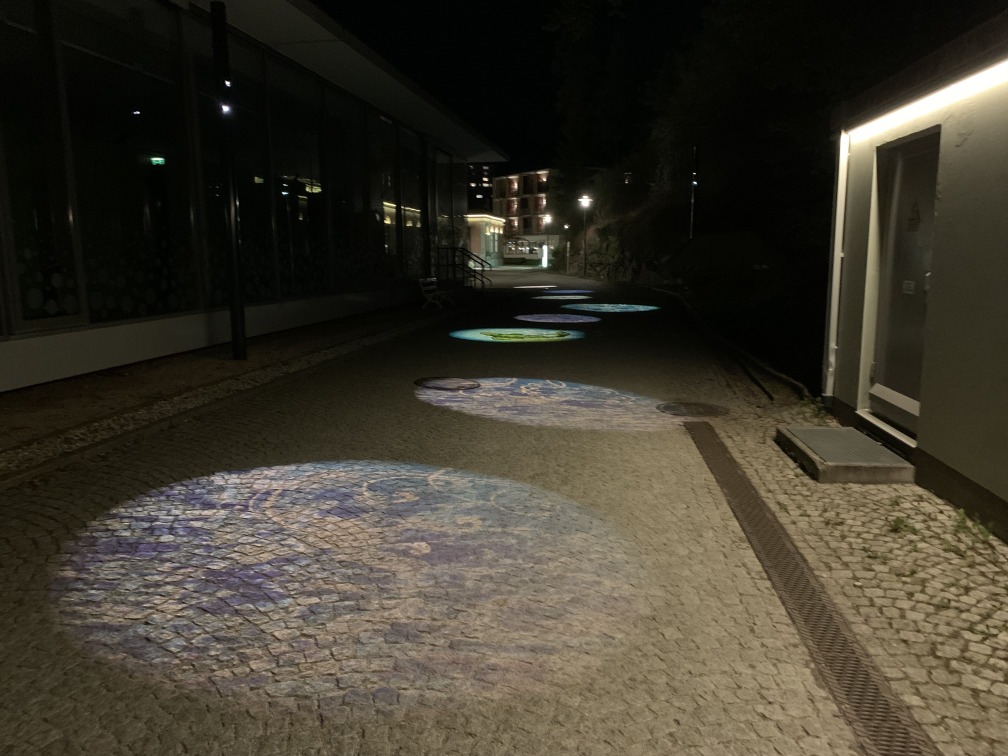 Gasse im Dunkeln mit Lichtbilder auf dem Boden