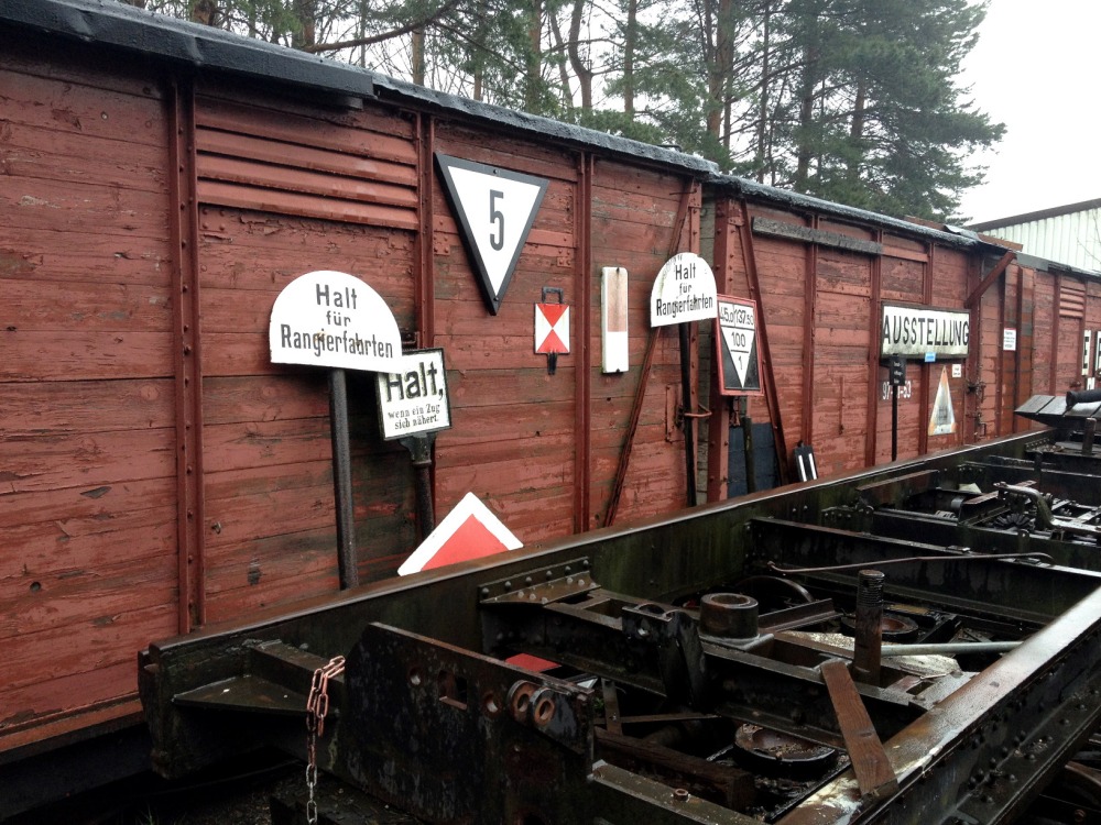 Schilder und Waggons am Bahnhof