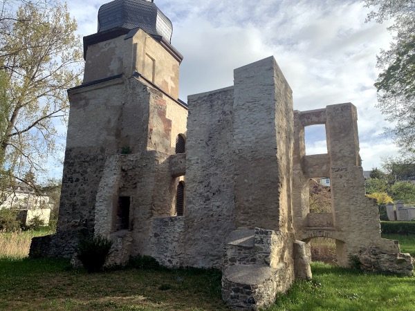 Steinmauern einer Ruine mit Fensterbgen auf Wiese