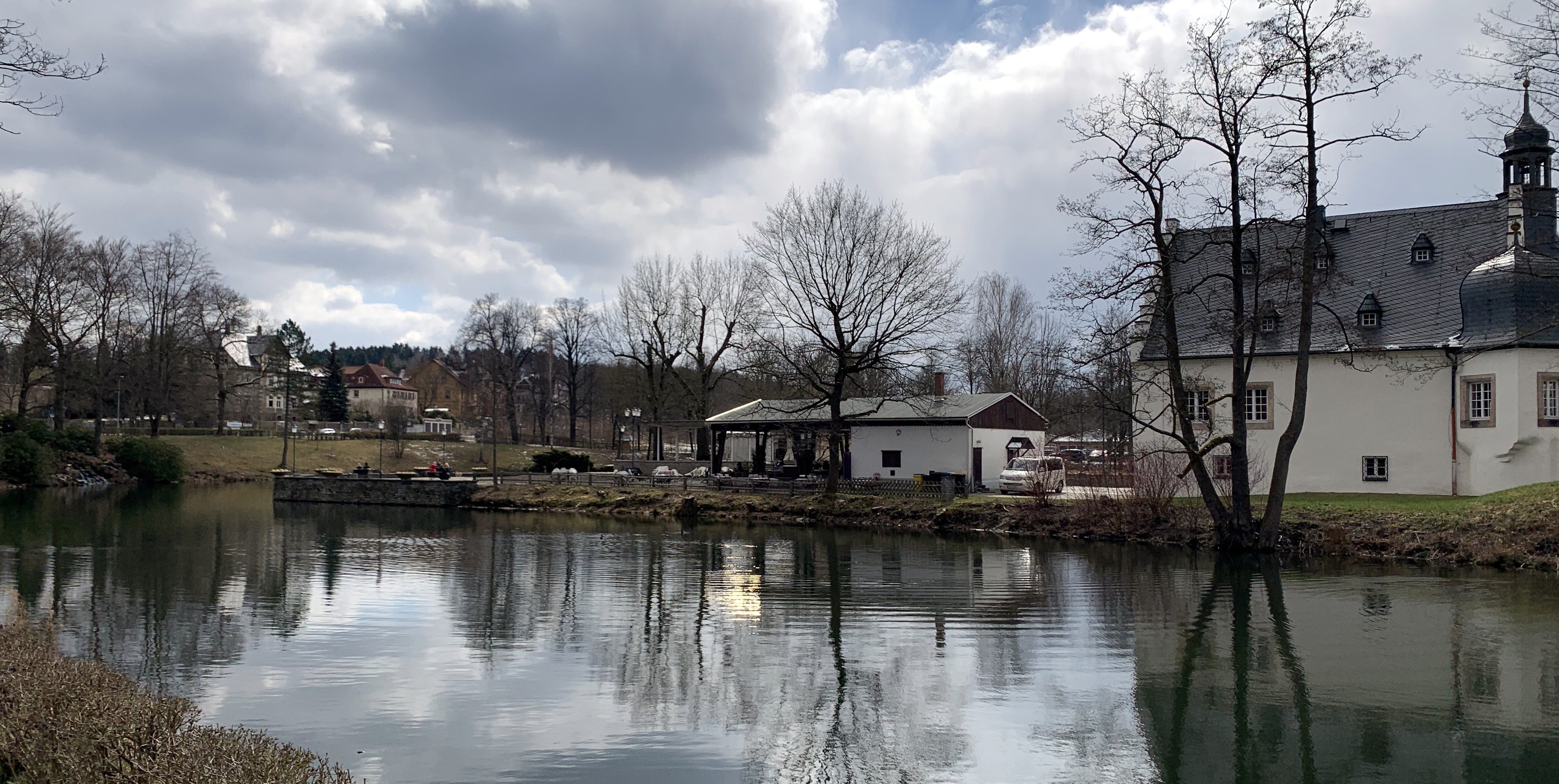 Objekte spiegeln sich im Wasser unter bewlktem Himmel