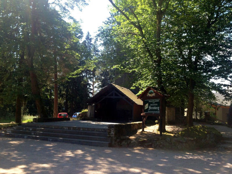 Treppen und Eingang auf steinerner Plattform zum Holzturm, Willkommensschild zur Steinberggaststätte