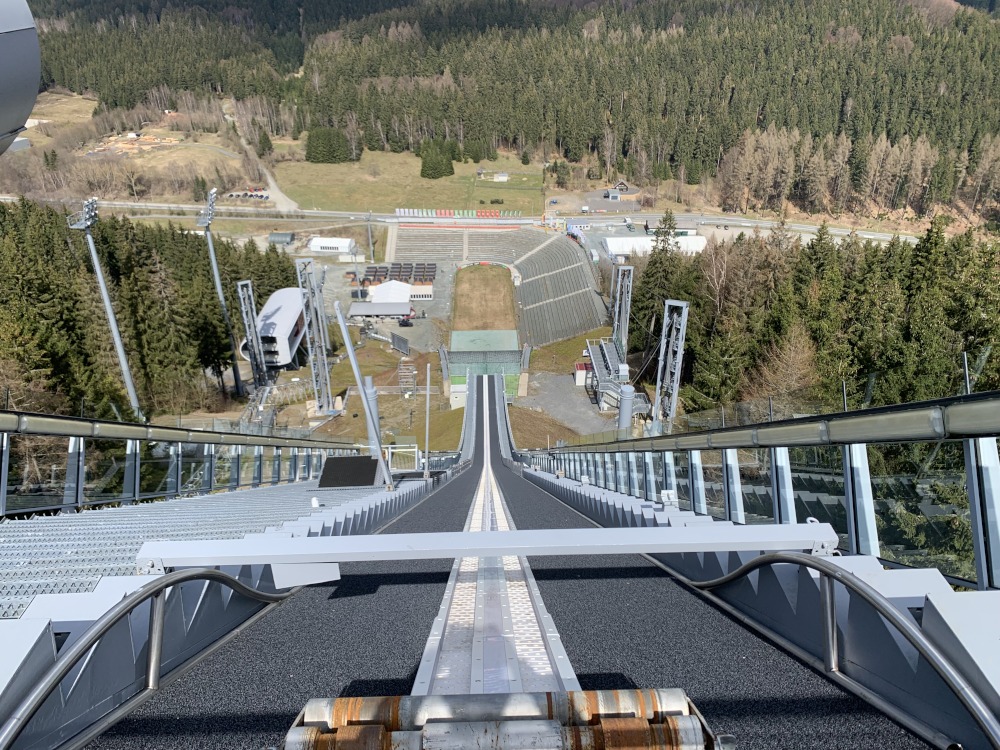 Blick von einer Sprungschanze von ganz oben nach unten ins Tal