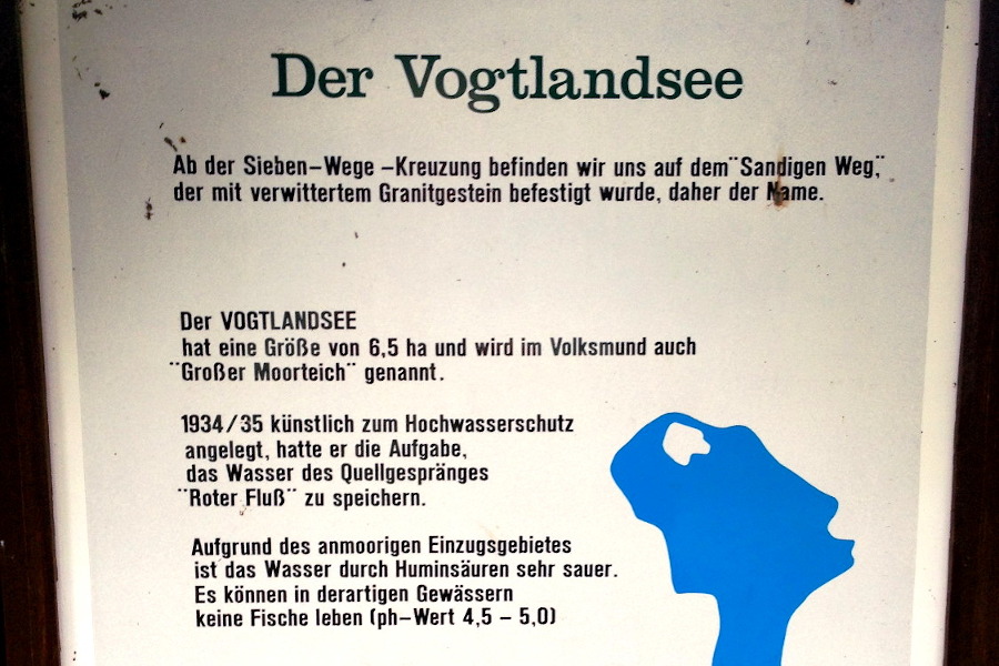 
						Der Vogtlandsee
						Ab der Sieben-Wege-Kreuzung befinden wir und auf dem Sandigen Weg, der mit verwittertem Granitgestein befestigt wurde, daher der Name.

						Der Vogtlandsee hat eine Gre von 6,5 ha und wird im Volksmund auch Groer Moorteich genannt.

						1934 und 1935 knstlich zum Hochwasserschutz angelegt, hatte er die Aufgabe das Wasser des Quellgesprnges roter Flu zu speichern.

						Aufgrund des anmoorigen Einzugsgebietes ist das Wasser durch Huminsuren sehr sauer.
						Es knnen in derartigen Gewssern keine Fische leben. (ph-Wert 4,5 - 5,0)

						Zu den Brutvgeln des Gebietes gehren Stockente, Reiherente und Zwergtaucher.

						Zehn verschiedene Libellenarten sowie Kreuzotter und Waldeidechse sind im Umfeld beheimatet.

						Verschiedene Torfmoosarten deuten auf den umgebenden Moorwald hin.
				